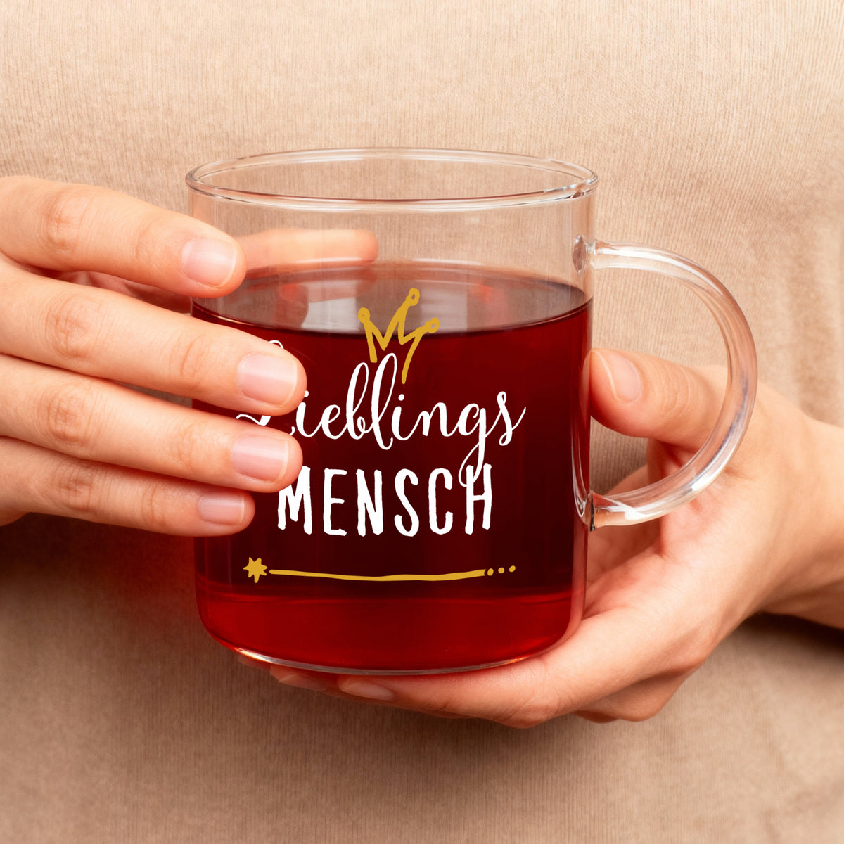 Leonardo-Teeglas mit Aufdruck „Lieblings Mensch“ in Weiß und Gold, gehalten in beiden Händen