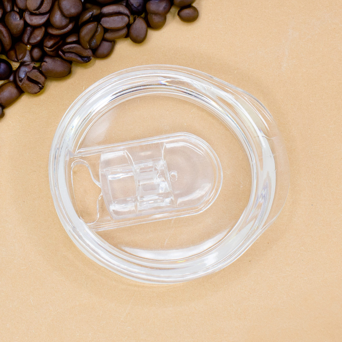 Abgenommener transparenter Deckel des Thermobechers, auf braunem Hintergrund mit Kaffeebohnen dekoriert