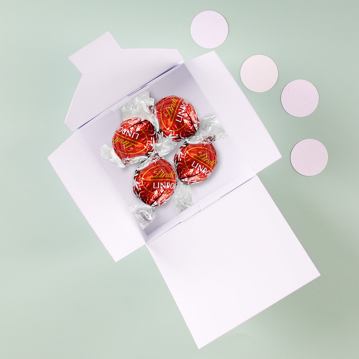 Geöffnete Oster Geschenkbox mit vier Lindor Kugeln im Inneren