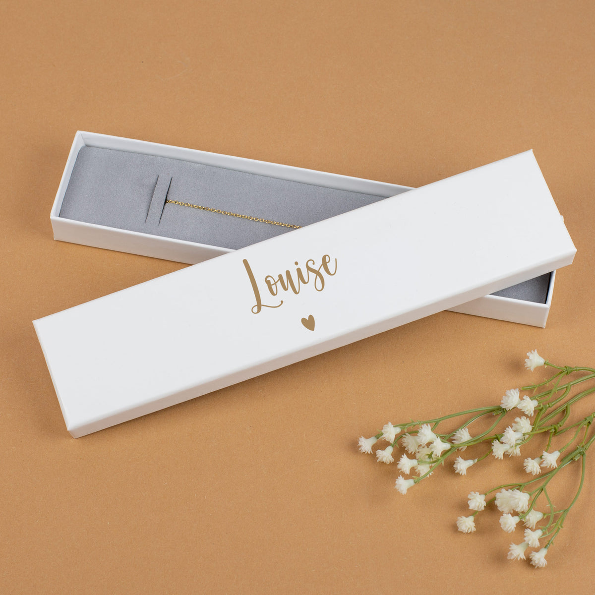 Weiß bedruckte Armbandbox mit Name „Louise“ in Gold, geöffnet mit grauem Einsatz