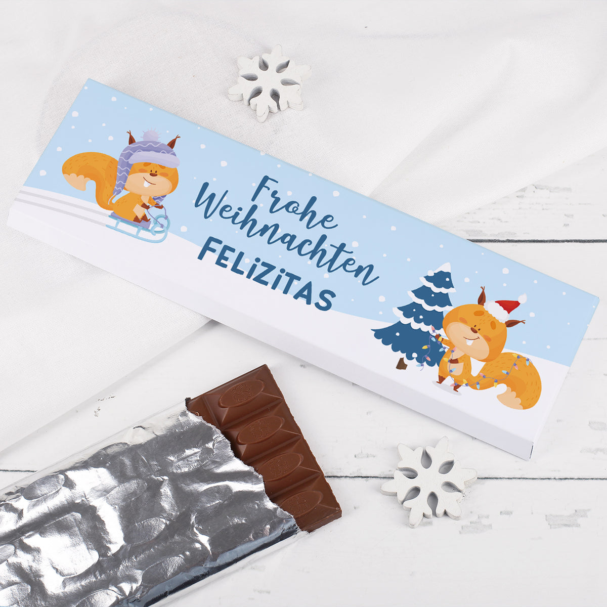 Personalisiert bedruckte Weihnachtsschokolade mit winterlichem Eichhörnchen-Motiv und Name Felizitas auf hellblauer Verpackung.