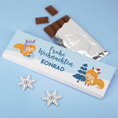 Weihnachtsschokolade mit Eichhörnchen und Name Konrad auf personalisierter Verpackung mit Schneeflocken.