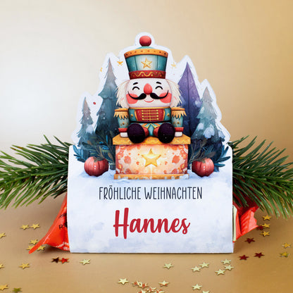 Mini-Stollen in personalisierter Nussknacker-Verpackung „Hannes“ mit festlichen Sternen und Tannengrün