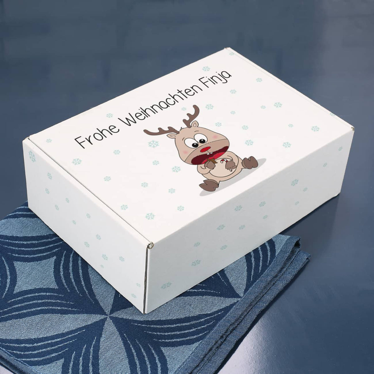 Geschenkverpackung mit niedlichem Rentier und Wunschtext