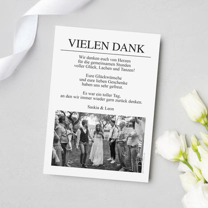 Rückseite der Hochzeits-Danksagungskarte im Zeitungsdesign mit Überschrift „VIELEN DANK“, persönlichem Dankestext und Foto in Schwarzweiß am unteren Rand