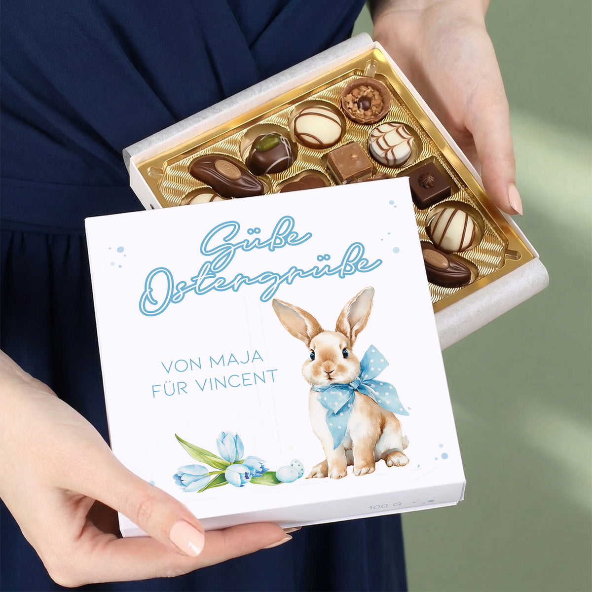 Person hält personalisierte Lindt Pralinenbox „Süße Ostergrüße“ mit Hasenmotiv