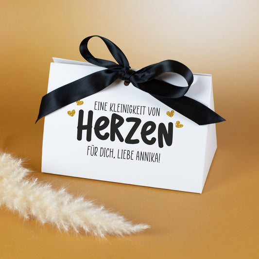Personalisierte Geschenkverpackung mit Aufdruck „Eine Kleinigkeit von Herzen“ und Wunschtext, geschlossen mit schwarzer Schleife
