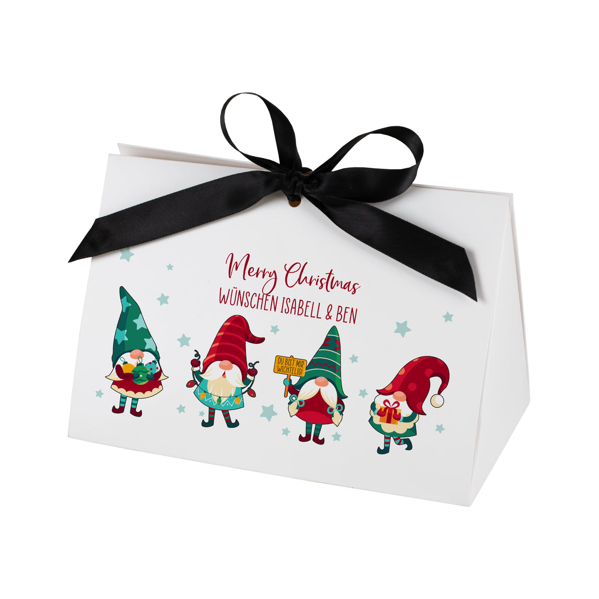Freigestellte Geschenkverpackung in Weiß mit festlicher schwarzer Schleife. Auf der Vorderseite befinden sich vier farbenfrohe Weihnachtswichtel und der personalisierte Text „Merry Christmas wünschen Isabell & Ben“. Die Sterne im Hintergrund und die kräftigen Farben des Motivs heben sich klar vor dem weißen Studiohintergrund ab.