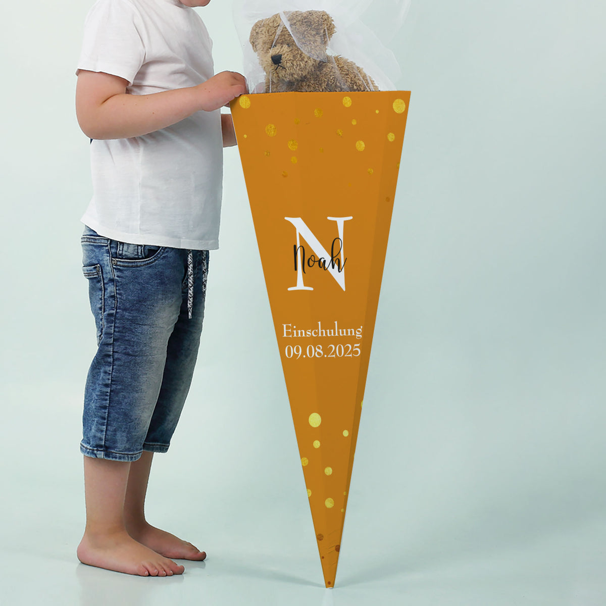 Junge mit orangefarbener Schultüte „Noah“, Datum der Einschulung darunter