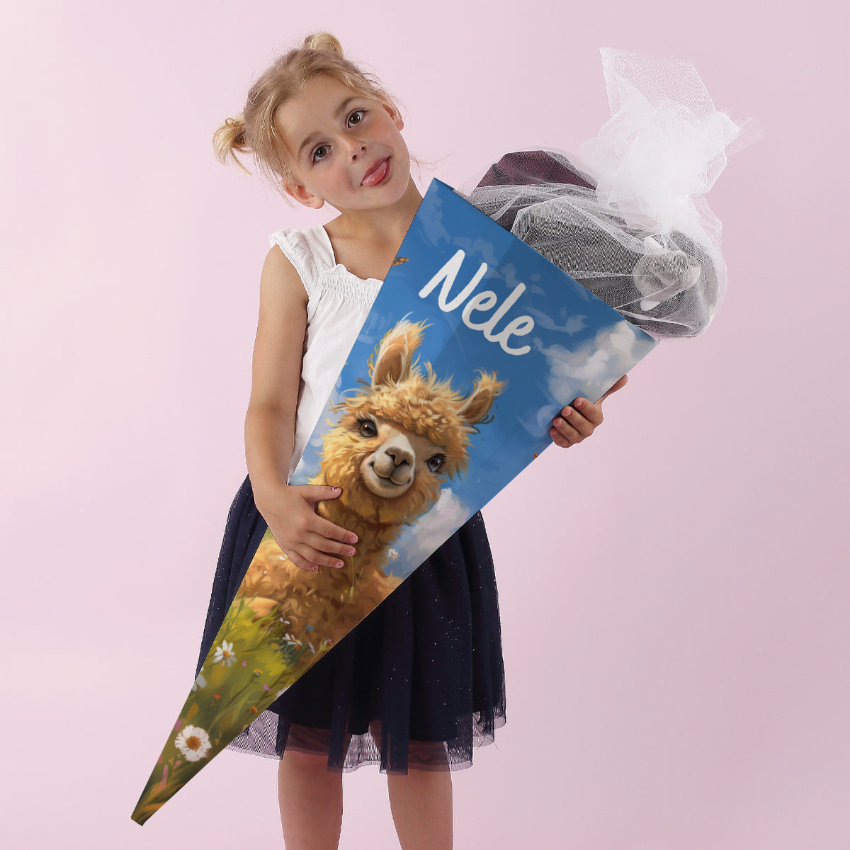 Mädchen hält eine große Schultüte mit Alpaka-Motiv und dem Namen „Nele“ vor rosa Hintergrund