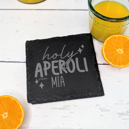 Schiefer-Untersetzer „holy Aperoli von Mia“ mit Orangenscheiben und Saft dekoriert