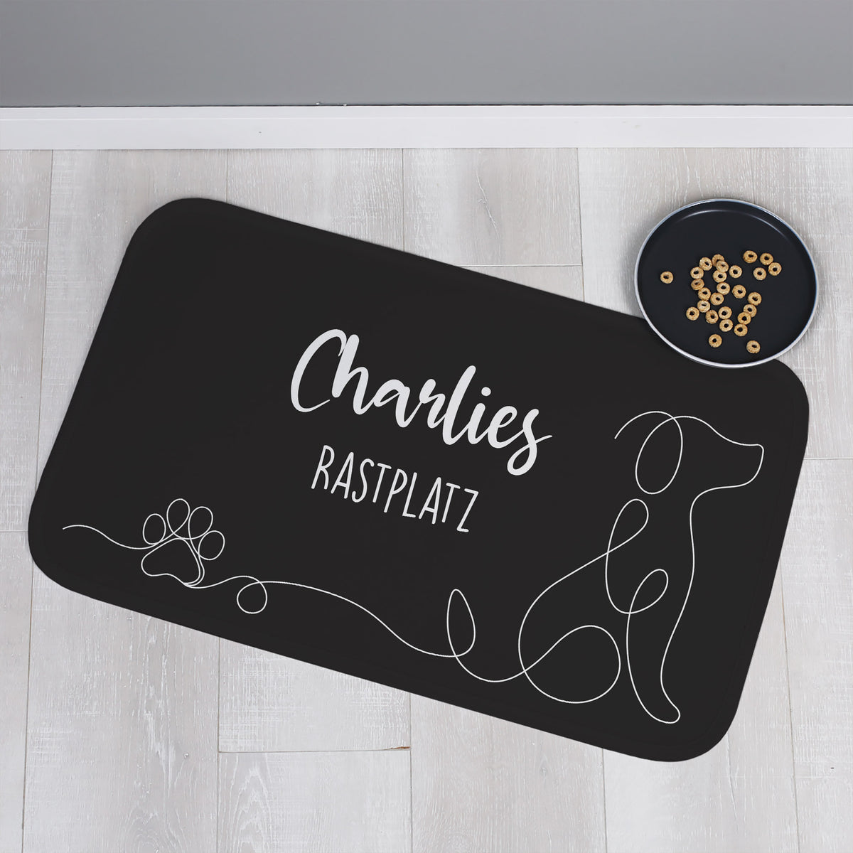 Personalisierbare schwarze Hundematte mit eigenem Text, frontal fotografiert, auf hellem Hintergrund.
