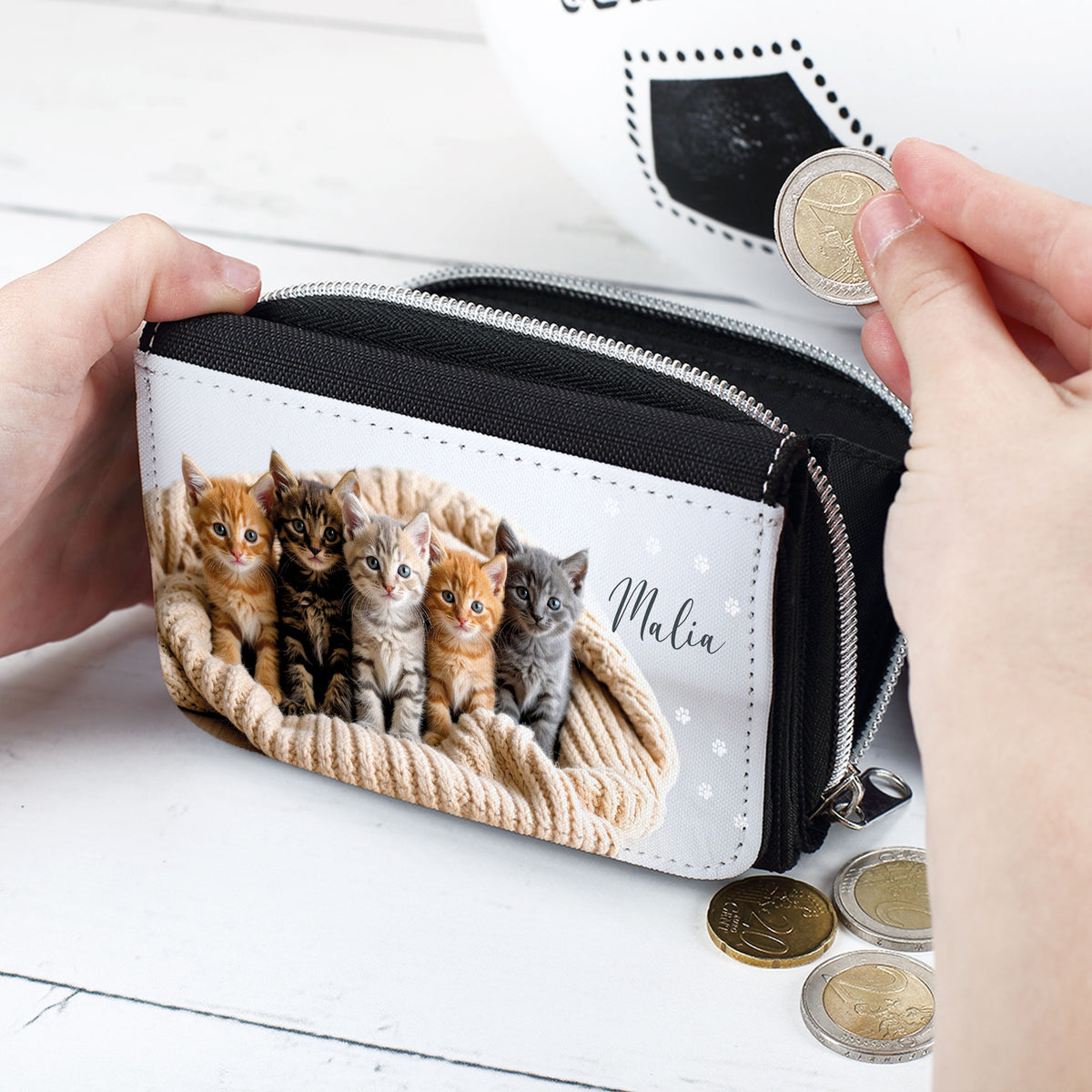 Personalisierte Geldbörse mit Katzenmotiv, Mädchenhand hält eine Münze