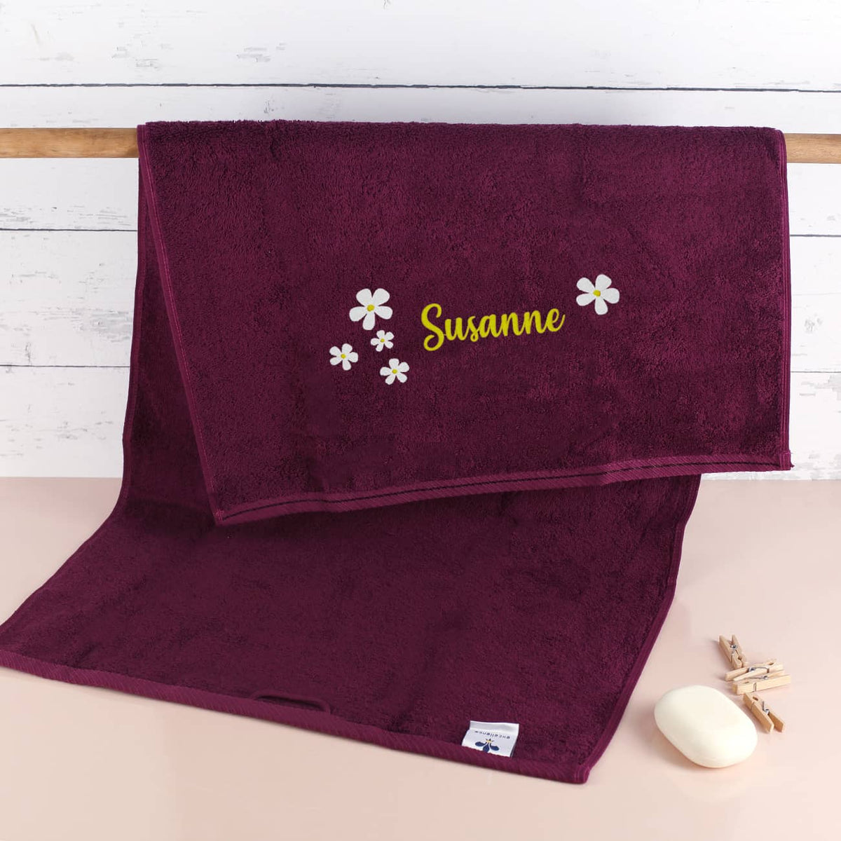 Brombeerfarbenes Handtuch mit Name und Blumen bestickt
