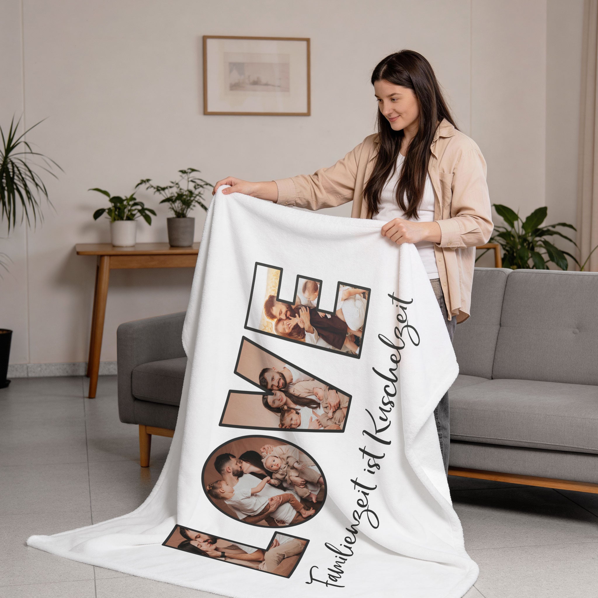 Fotodecke XXL mit LOVE Schriftzug aus vier Bildern und Spruch „Familienzeit ist Kuschelzeit“, gehalten von einer Frau im Wohnzimmer