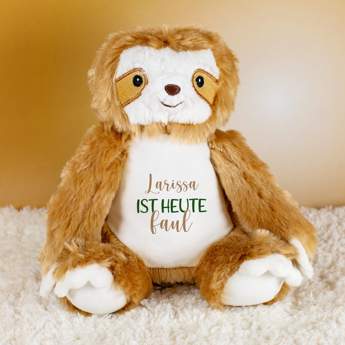 Kuscheltier Faultier mit Aufdruck „Larissa ist heute faul“, personalisiert mit Name, auf hellem Teppich.