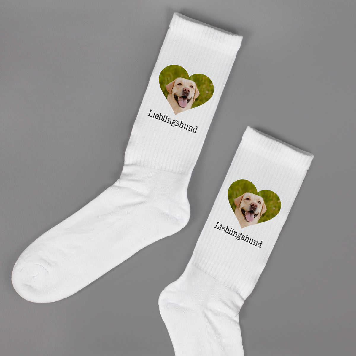 Paar weiße Socken mit Herzfoto und Wunschtext „Lieblingshund“, Produktfoto freigestellt auf grauem Hintergrund