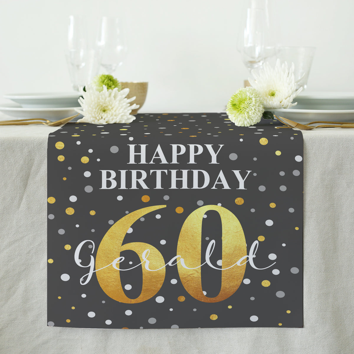 Schwarzer Tischläufer mit goldenem „Happy Birthday“-Schriftzug, Konfetti-Muster sowie personalisiertem Namen und Alter, dekorativ auf einem gedeckten Tisch platziert.