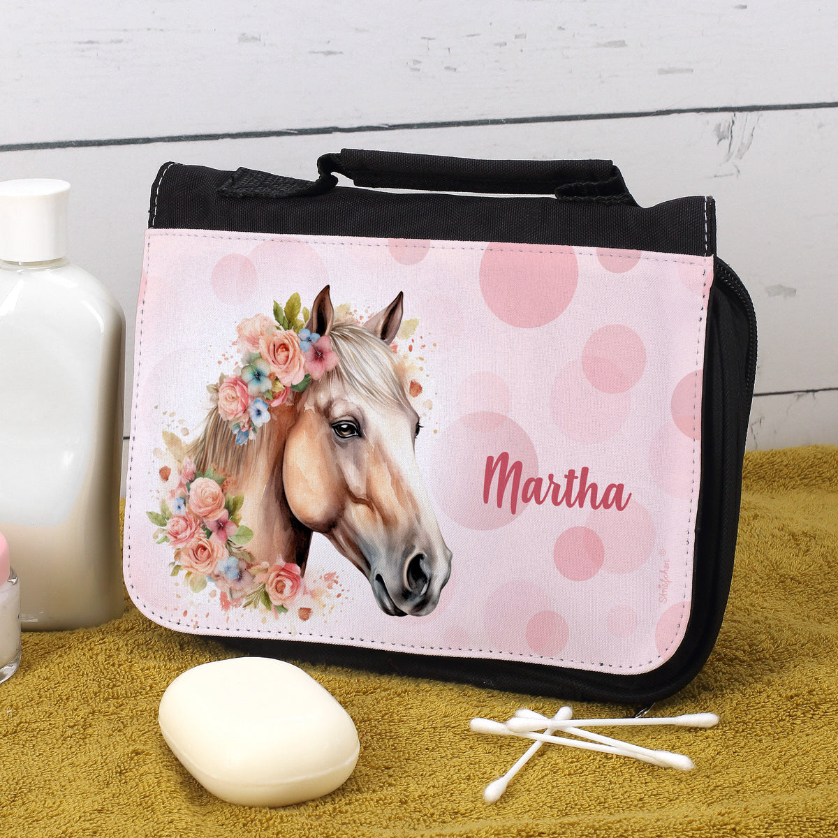 Kulturtasche mit Pferdemotiv und Name „Martha“, fotografiert auf gelbem Handtuch mit Duschutensilien
