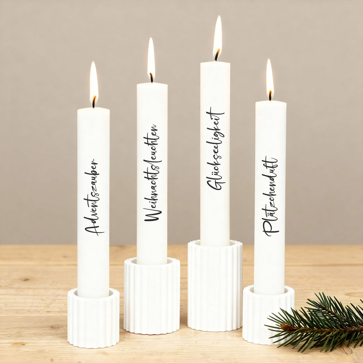 Stabkerzen mit Wunschtext, brennend in weißen Kerzenhaltern, festliche Adventsdekoration.