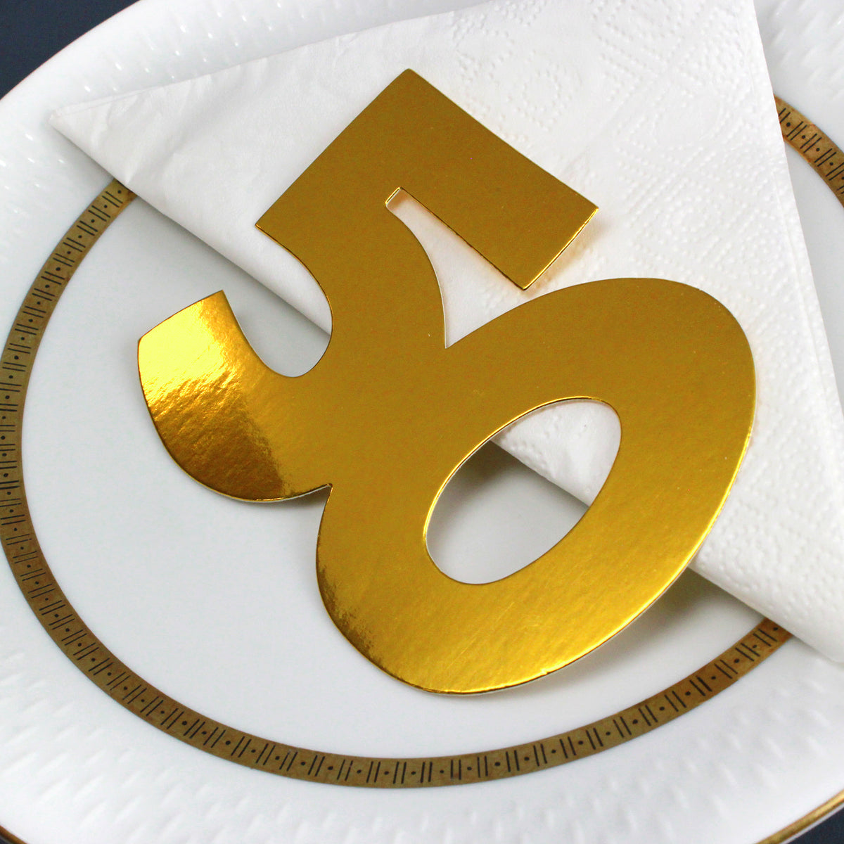 Goldenes Jumbo-Konfetti Zahl 50 als Tischdekoration auf Serviette zur Goldenen Hochzeit