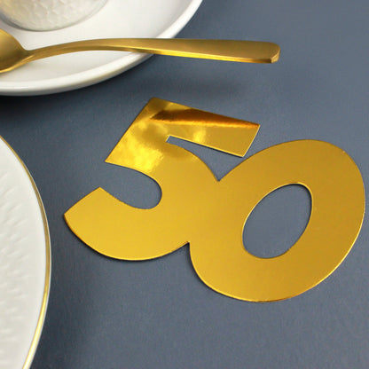 Jumbo-Konfetti Zahl 50 in Gold als Tischdekoration mit Tasse und goldenem Löffel