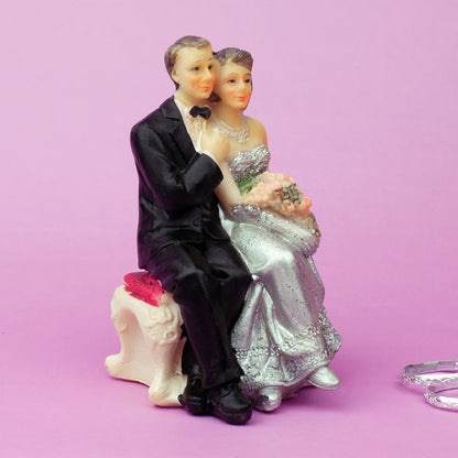 Rückansicht Hochzeitspaar sitzend mit Fliege und Brautkleid in Silber