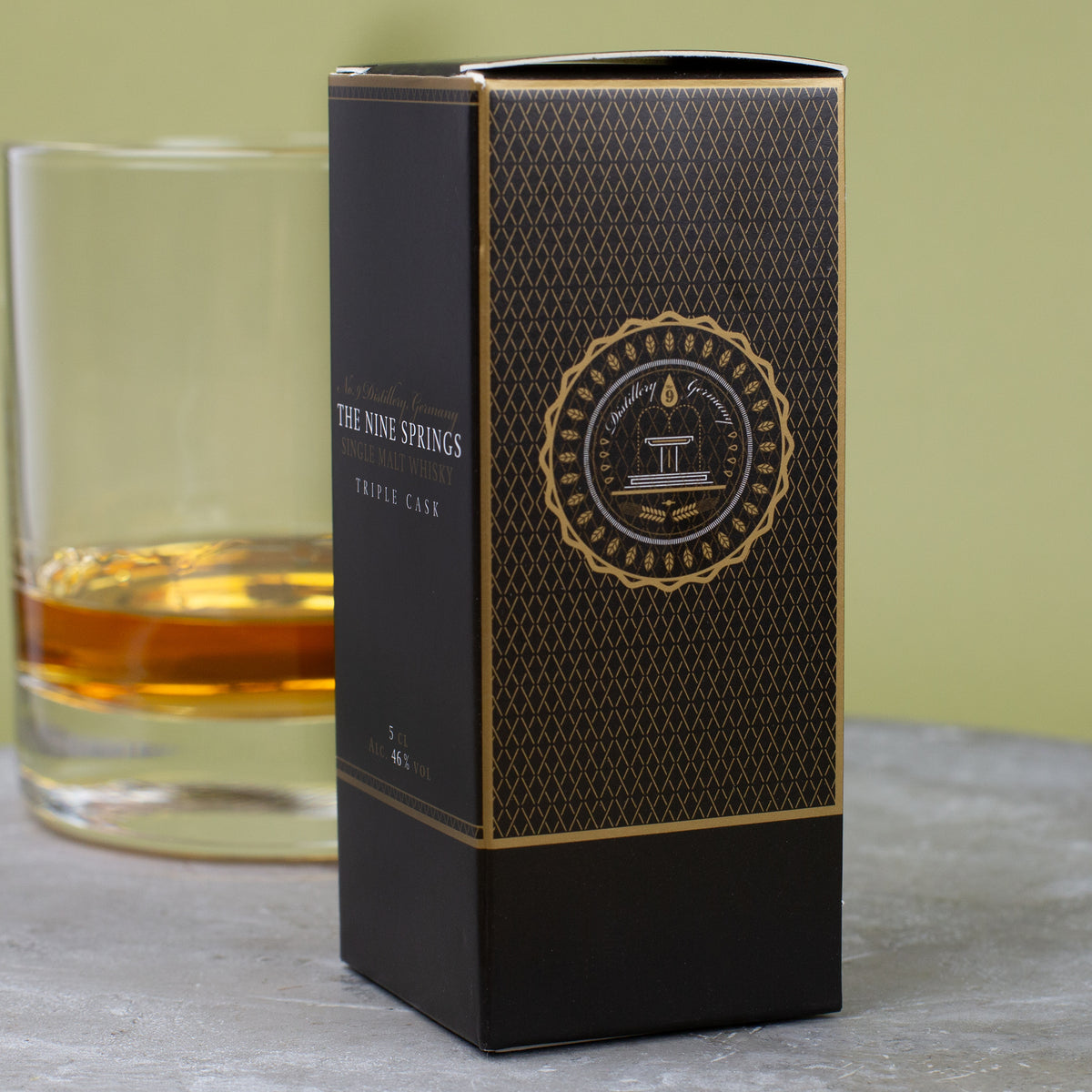 Rückseite der Geschenkbox The Nine Springs Triple Cask Whisky Miniatur, schwarz-goldenes Design